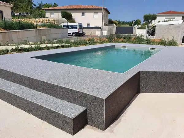 Plage de piscine en tapis de pierre